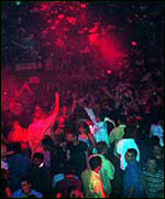 nightclub scene with people dancing and coloured lights
