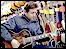 Man playing the guitar in a music shop on Barton Street in Gloucester