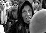 A Palestinian woman brandishes helmets during a memorial service in Beirut