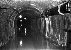 View showing a flooded tunnel. The metal horseshoe ribs which were put in place to uphold the ceiling can clearly be seen