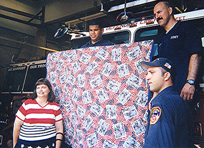 Mary shows off the back of the quilt with some of the firefigthers