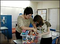 Claire Williams helps student unpack toys