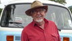 Rolf Harris standing in front of a camper van