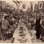 This is a street party on VE day held at Wesley Grove Portsmouth. My parents are in the forground my father to the right wearing his office suit my mother is at the front on the left. This is a street party on VE day held at Wesley Grove Portsmouth. My parents are in the forground my father to the right wearing his office suit my mother is at the front on the left.
