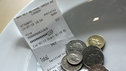 A restaurant receipt and some coins