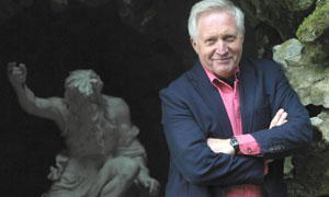 David Dimbleby with statue of Neptune at Stourhead Gardens