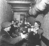 Image of a woman pouring a drink in an underground shelter in London, 1940