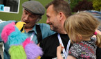 Mark Radcliffe, Mike Waterson and Martin Simpson and Molly Simpson relax backstage in the Friday sunshine.