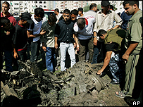 فلسطينيان در اطراف لاشه يک خودروی استيشن