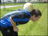 Teenager balances ball on neck 