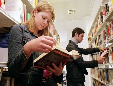 People looking at books in a library People looking at books in a library