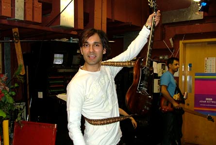 DJ Swami practises his guitar poses backstage 