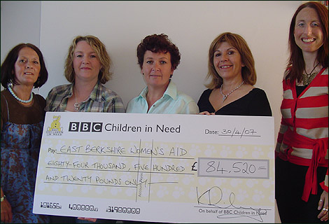 Maggie (second from right) hands over the cheque