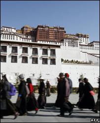 Tibetanos passam em frente ao palácio Potala, em Lhasa