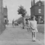 Irene M. M. Taylor in a Street just off  Liverpool Road, Eccles circa 1931 with Jack Ormesher close by his soft-top car and two local children in on the photo