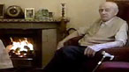 Man sits by fire
