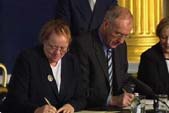 Image of the Secretary of State Mo Mowlam and the Irish Foreign Affairs Minister David Andrews signing the treaties regulating the North-South Ministerial Council, 8 March 1999