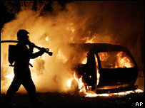 Bombeiro tenta apagar incêndio em um carro em "Les Musicians", um complexo habitacional do subúrbio de Les  Mureaux, noroeste de Paris, no sábado, 5 de novembro.