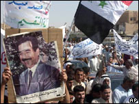 Manifestantes carregam foto de Saddam Hussein em manifestação no Iraque