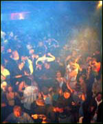nightclub scene with people dancing and coloured lights