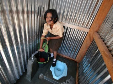 Girl enjoys new toilet in school in Indonesia, photo courtesy of UNICEF