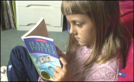 Young girl reading Harry Potter book 