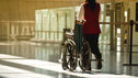 A wheelchair user receiving assistance at an airport terminal