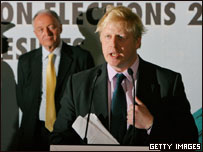 Boris Johnson, prefeito eleito de Londres, faz discurso de vitória e é observado, ao fundo, pelo adversário derrotado, Ken Livingstone