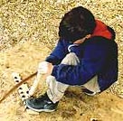 Image of a boy using the wood friction method to make fire