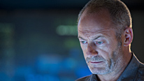 Tate (Liam Cunningham) needs to find a way to communicate with the host force