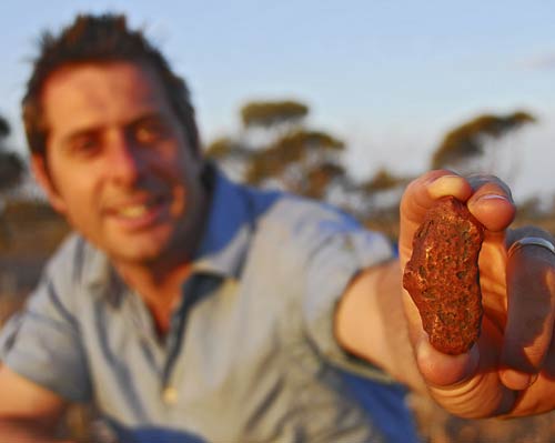 Dr Iain Stewart with meteorite found on Nullarbor Plain, south western Australia