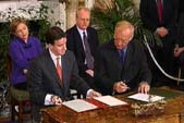 Image of Northern Ireland Secretary Peter Mandelson and Irish Foreign Affairs Minister David Andrews signing the new British-Irish Treaty in Dublin, 2 December 1999