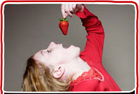Small child eating a strawberry