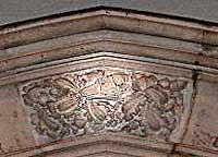 Carved dog's head surrounded by foliage